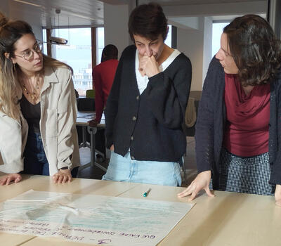 3 travailleuses discutent autour d'une table