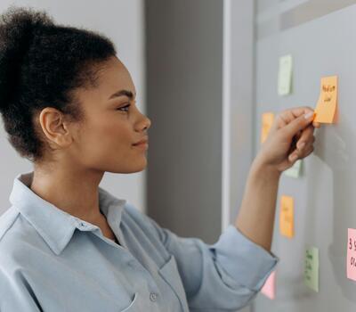 Une femme pose un post-it