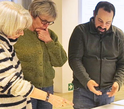 trois personnes discutent autour d'une table